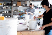 Students participating in a Vancouver pottery glaze workshop, learning how to mix and apply ceramic glazes in a professional studio setting. The workshop focuses on the chemistry of ceramic glazes, helping participants refine their glazing techniques for pottery and ceramics.